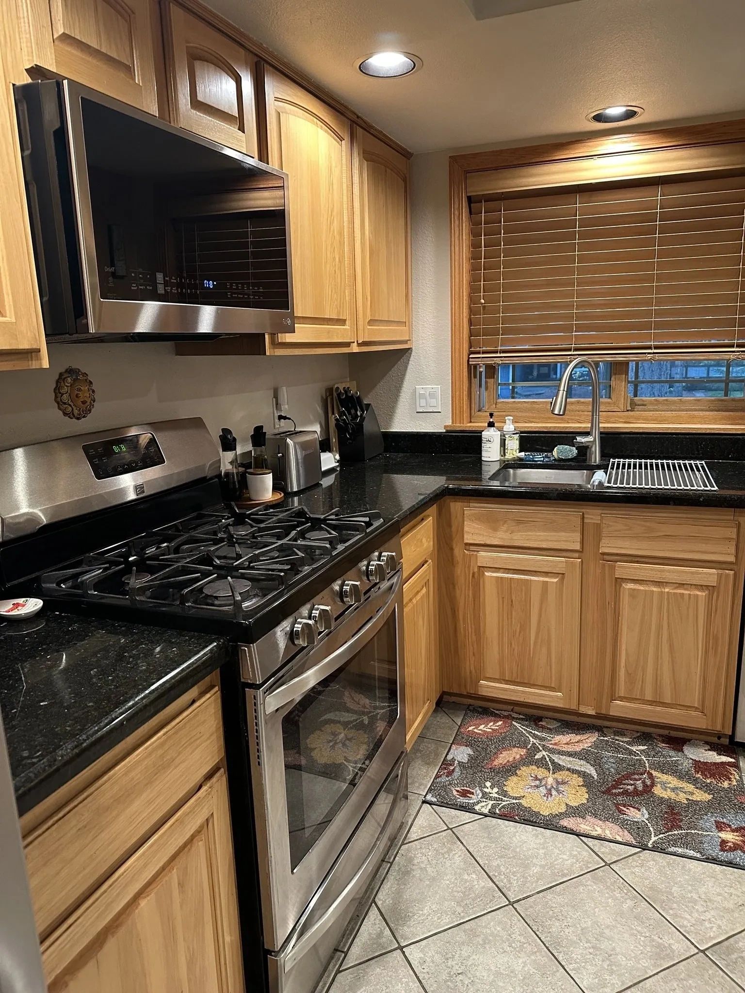 Modern kitchen with wood cabinets and stainless steel appliances.