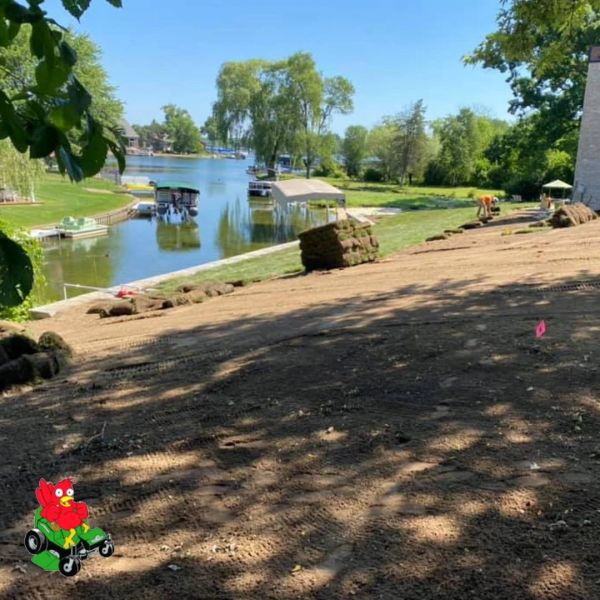 Landscaping work near a lakeside with rolled sod.