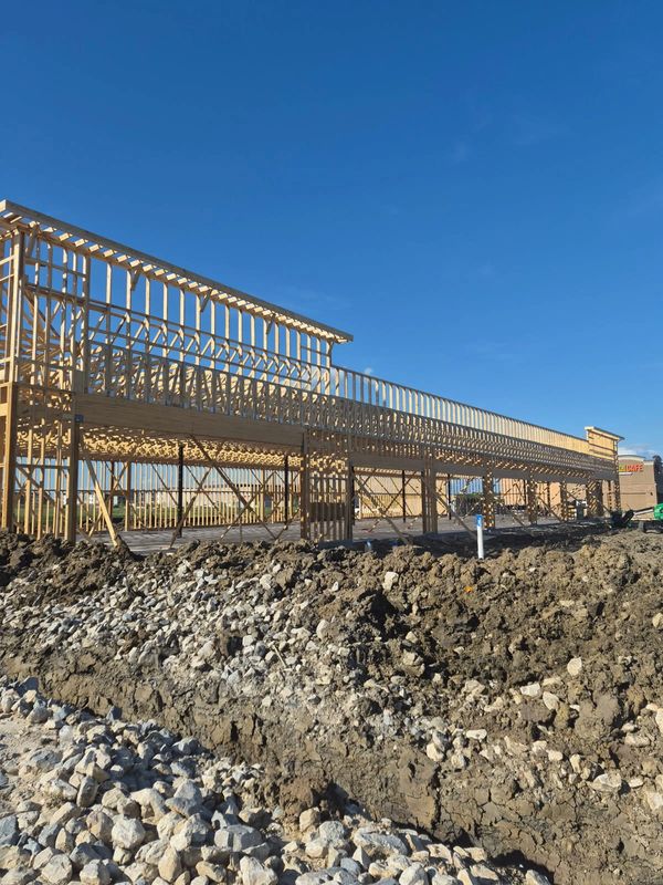 Wooden framework of a building under construction on a clear day.