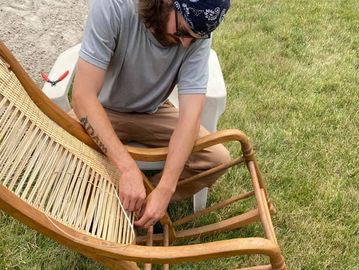Man repairing wooden rocking chair. 