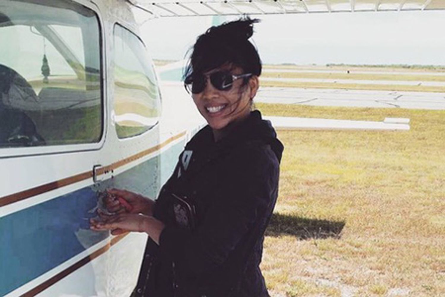 Smiling First Officer Anh K. Ho posing in front of her plane.