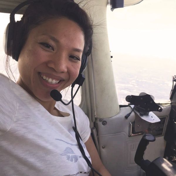 Smiling First Officer Anh with her headset, flying her plane.