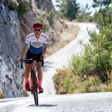 Gamze Ceyhan bisikletinin üstünde ayağa kalkmış ve güçlü pedallarla kendinden emin şekilde ilerliyor.