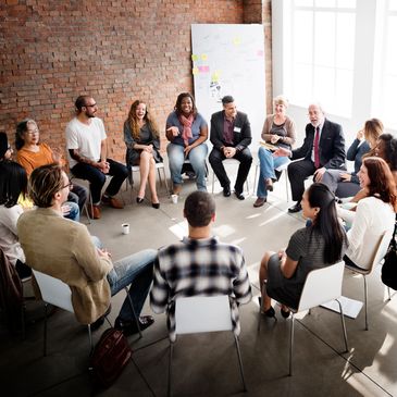A diverse group of people sitting in a circle engaged in a lively discussion.