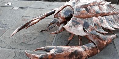 giant copper flame marked bug sculpture