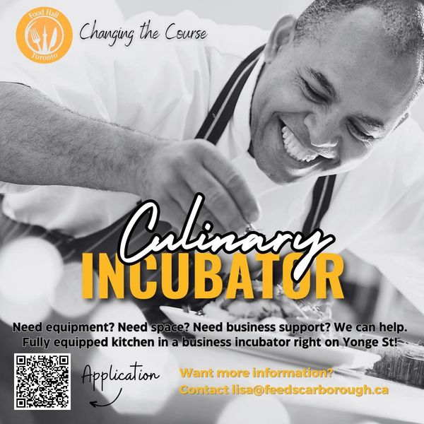 Chef happily plating food in a culinary incubator kitchen on Yonge St.