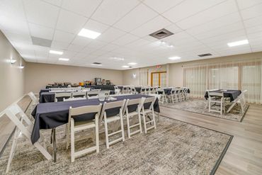 A clean, spacious banquet hall with tables and chairs set up for an event.