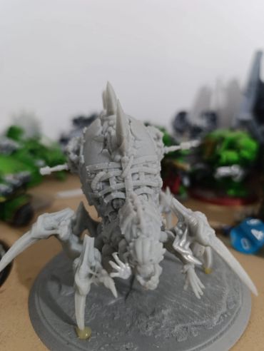 Unpainted skeletal dragon miniature on a textured base.