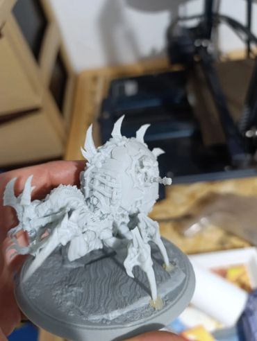 A detailed unpainted miniature of a spider-like creature with spikes.