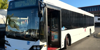 A white city bus parked with its door open.