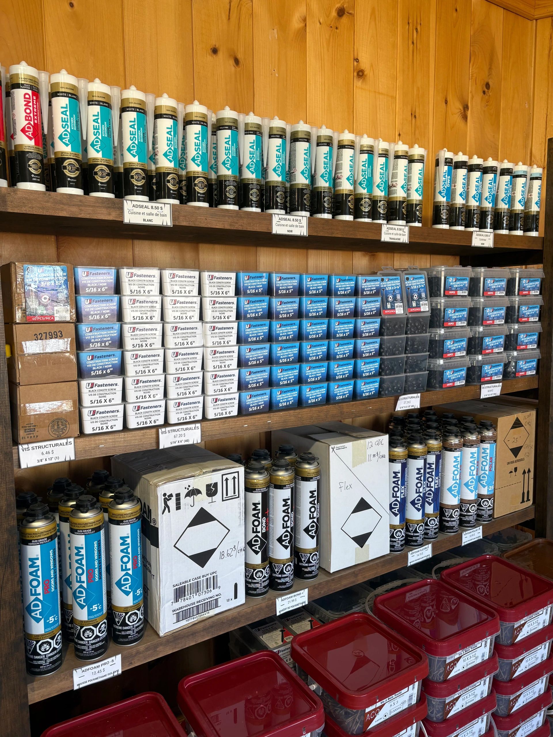 Shelves stocked with ADSEAL adhesives, ADFOAM insulating foam, and construction screws.
