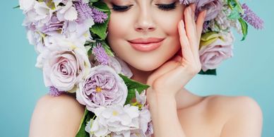 Woman with a serene smile surrounded by a crown of pastel flowers.