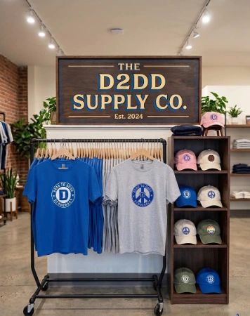 Display of branded t-shirts and caps at The D2DD Supply Co.