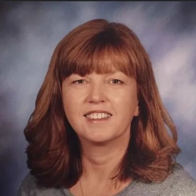 Portrait of a smiling woman with shoulder-length reddish hair.