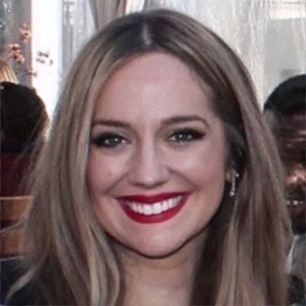 Smiling woman with long blonde hair and bold red lipstick.