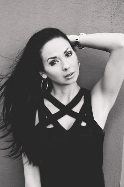 Black-and-white portrait of a woman with long hair and hoop earrings.