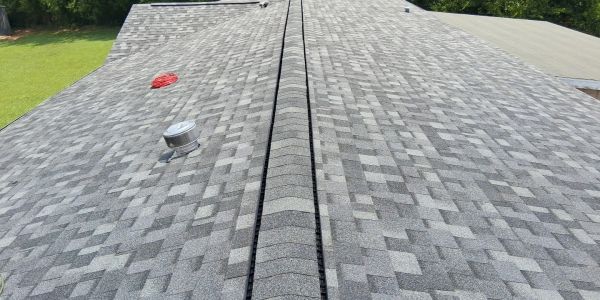 Newly installed gray shingle roof with ridge vent.