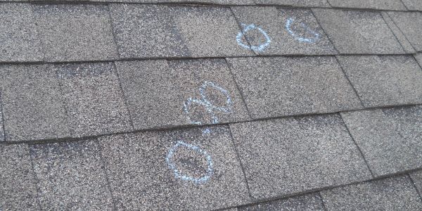 Chalk circles marked on a roof with asphalt shingles.