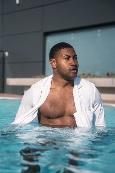 african american man swimming in the pool with white suit jacket