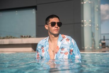 man swimming in the pool with hawaiian swim suit