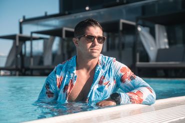 man in the pool swimming with hawaiian swim suit jacket