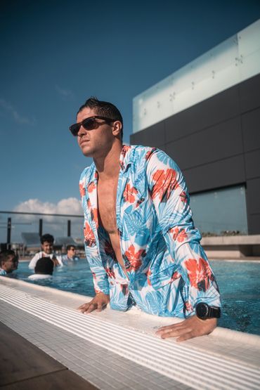 man wearing hawaiian suit jacket getting out of the pool