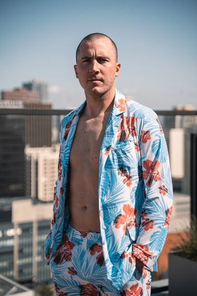 standing man wearing hawaiian swim suit jacket and shorts