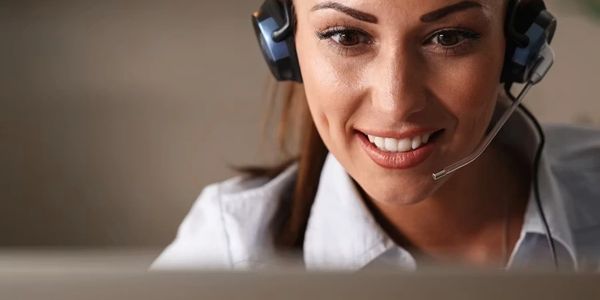 Smiling woman wearing a headset, focused on her work.