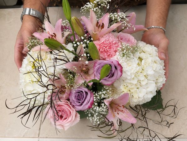 A colorful bouquet of mixed flowers being held.