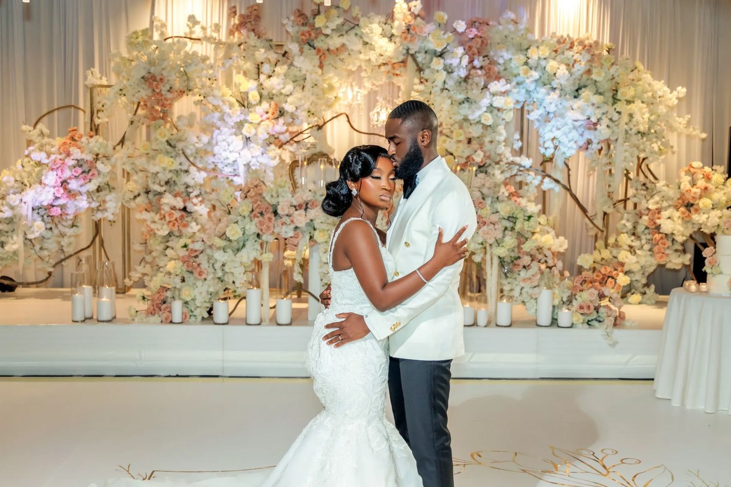 Bride and groom sharing a tender moment during their wedding with floral decorations.