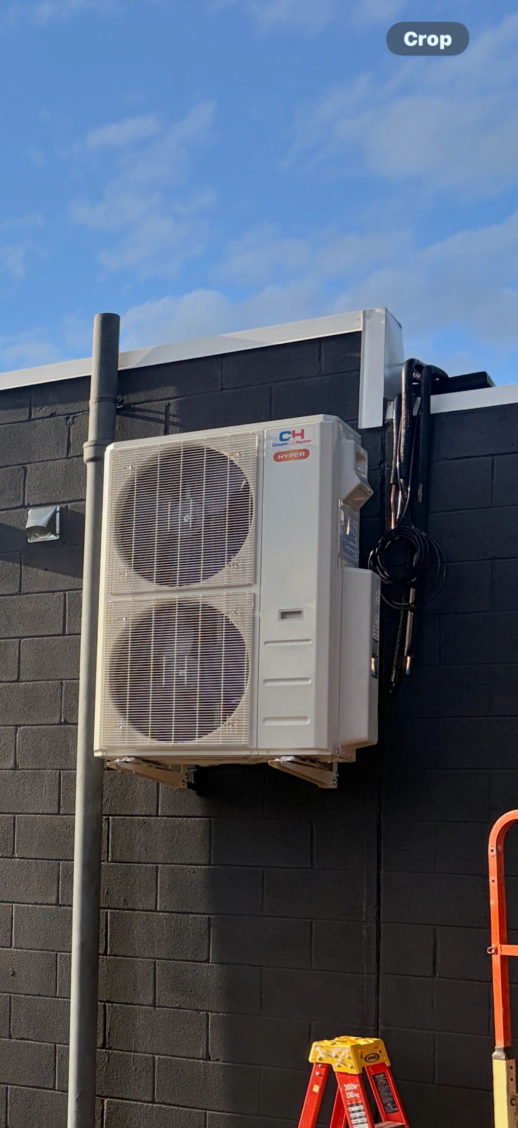 Air conditioning unit mounted on a black wall.