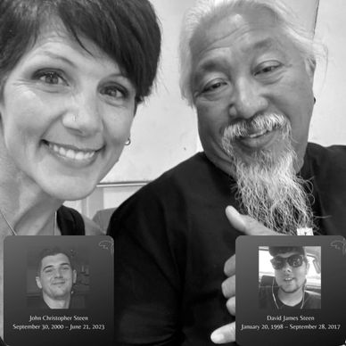 Two people smiling in a selfie with memorial photos overlayed.