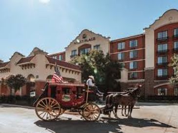 Horse-drawn carriage in front of a historic-style hotel building.