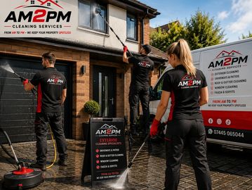 AM2PM cleaning crew power washing a brick driveway and wall.