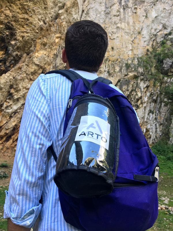 Arto Pillow - Memory Foam + in its carrying case, attached to a backpack.