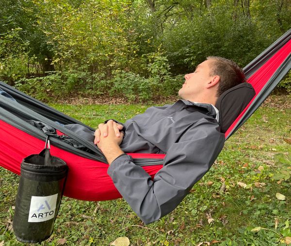 Arto Pillow - Memory Foam being used while a man sleeps in a hammock. 