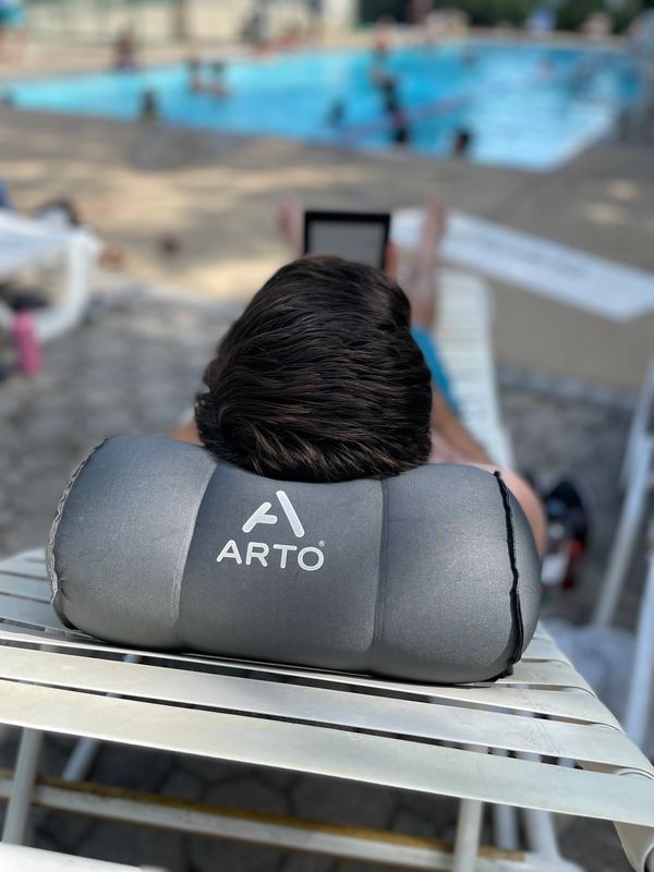 Man using the Arto Pillow - Inflatable while at the pool. 