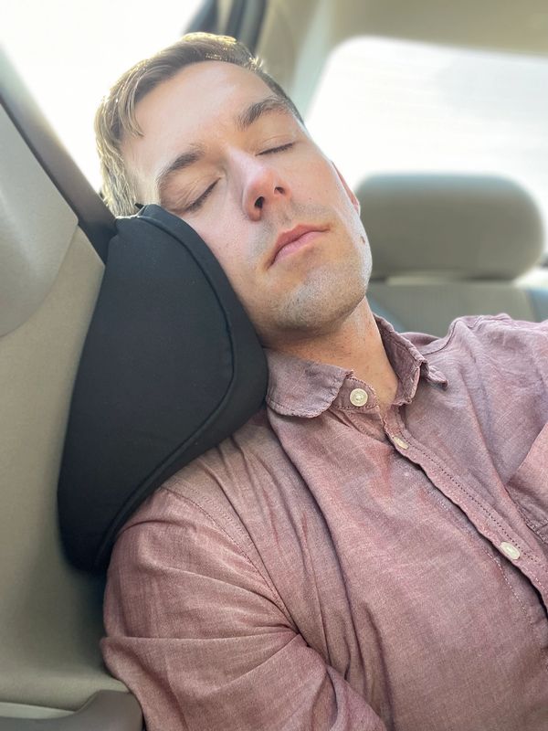 Man sleeping on an Arto Pillow - Memory Foam while in a car. 