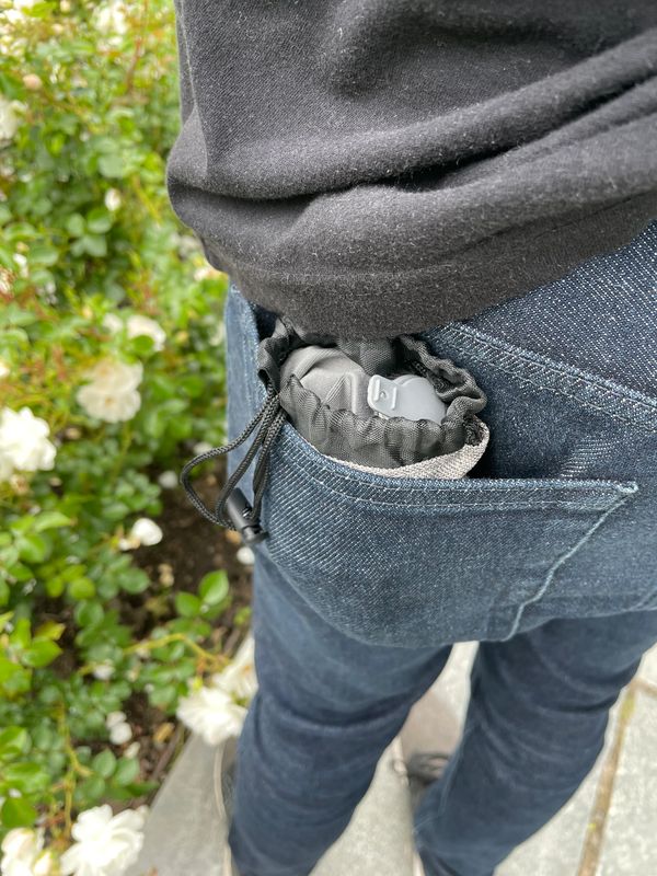 The Arto Pillow - Inflatable in it's carrying case, sitting in a man's back pocket. 