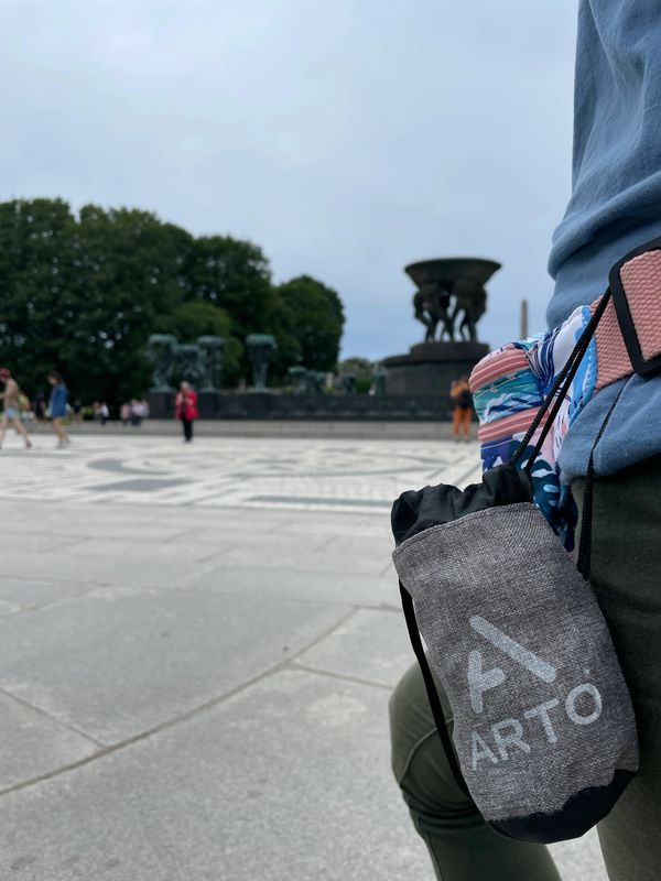 The Arto Pillow - Inflatable in it's carrying case, attached to a woman's belt. 