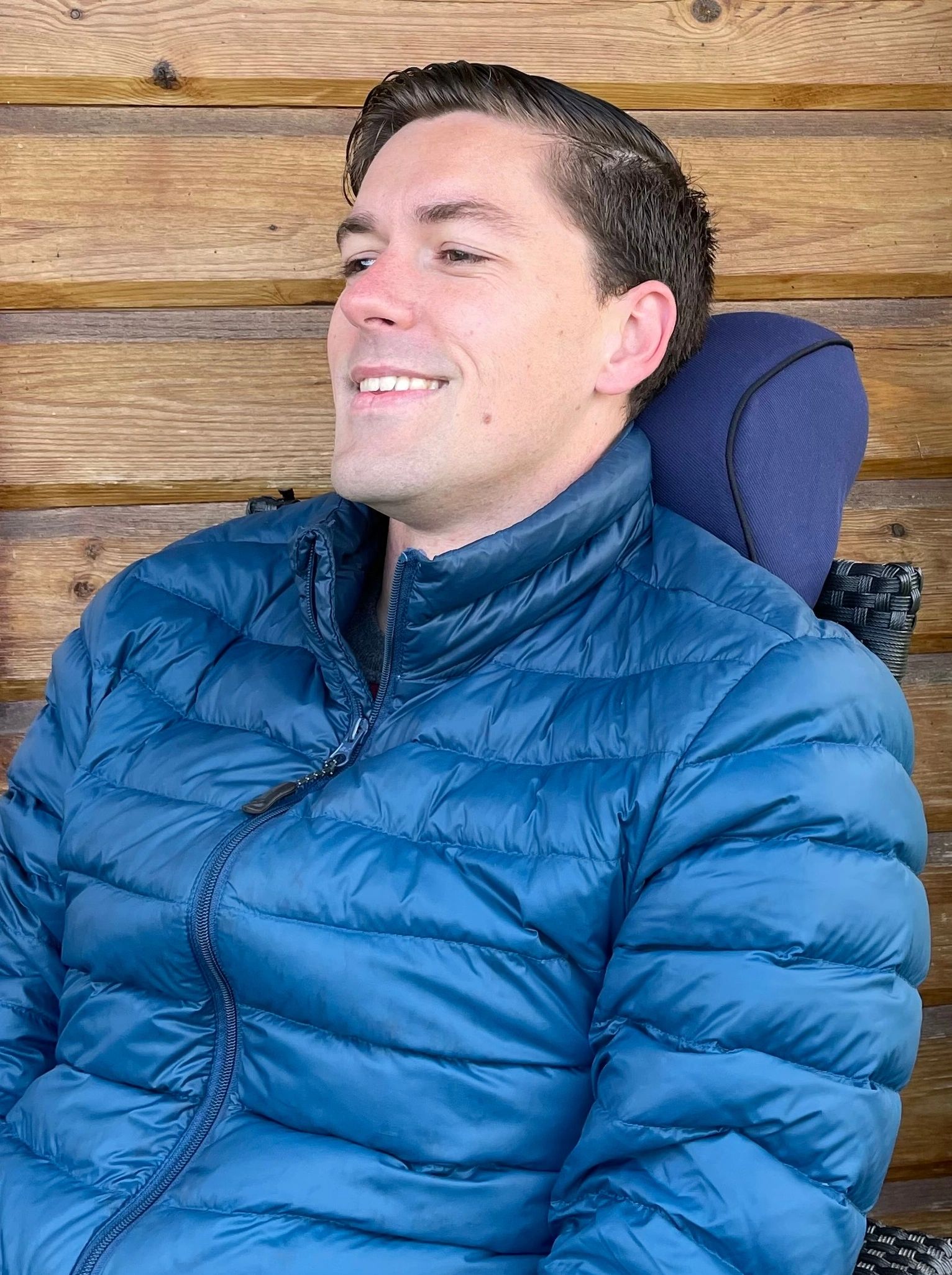 Man sitting in chair with the Arto Pillow- Memory Foam supporting his neck and back of head.  