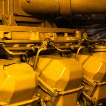 Close-up of a yellow industrial engine with multiple components.