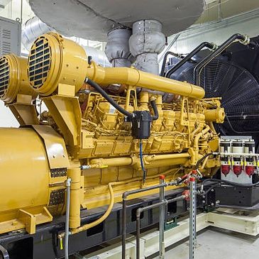 Large industrial yellow engine inside a clean mechanical room.