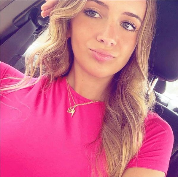 Young woman with long wavy hair in a red shirt.