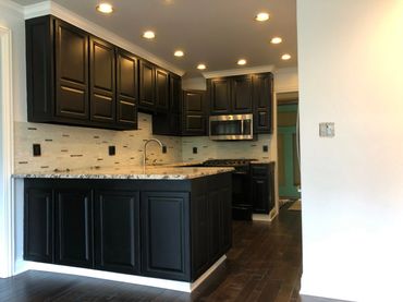 Modern kitchen with dark cabinets and granite countertop.