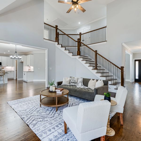 Bright living room with staircase and open kitchen.
