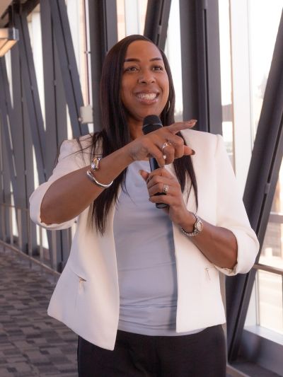 Woman speaking with a microphone indoors.