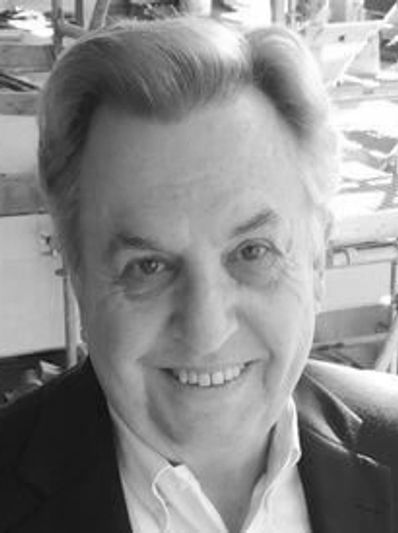Smiling man in suit jacket indoors.