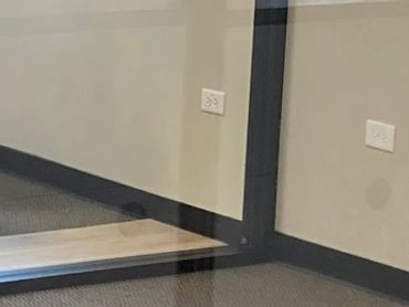 Oficina vacía con paredes de vidrio y ventanas.