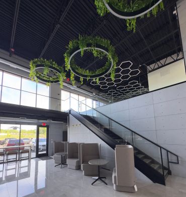Modern lobby with green ceiling rings and seating.